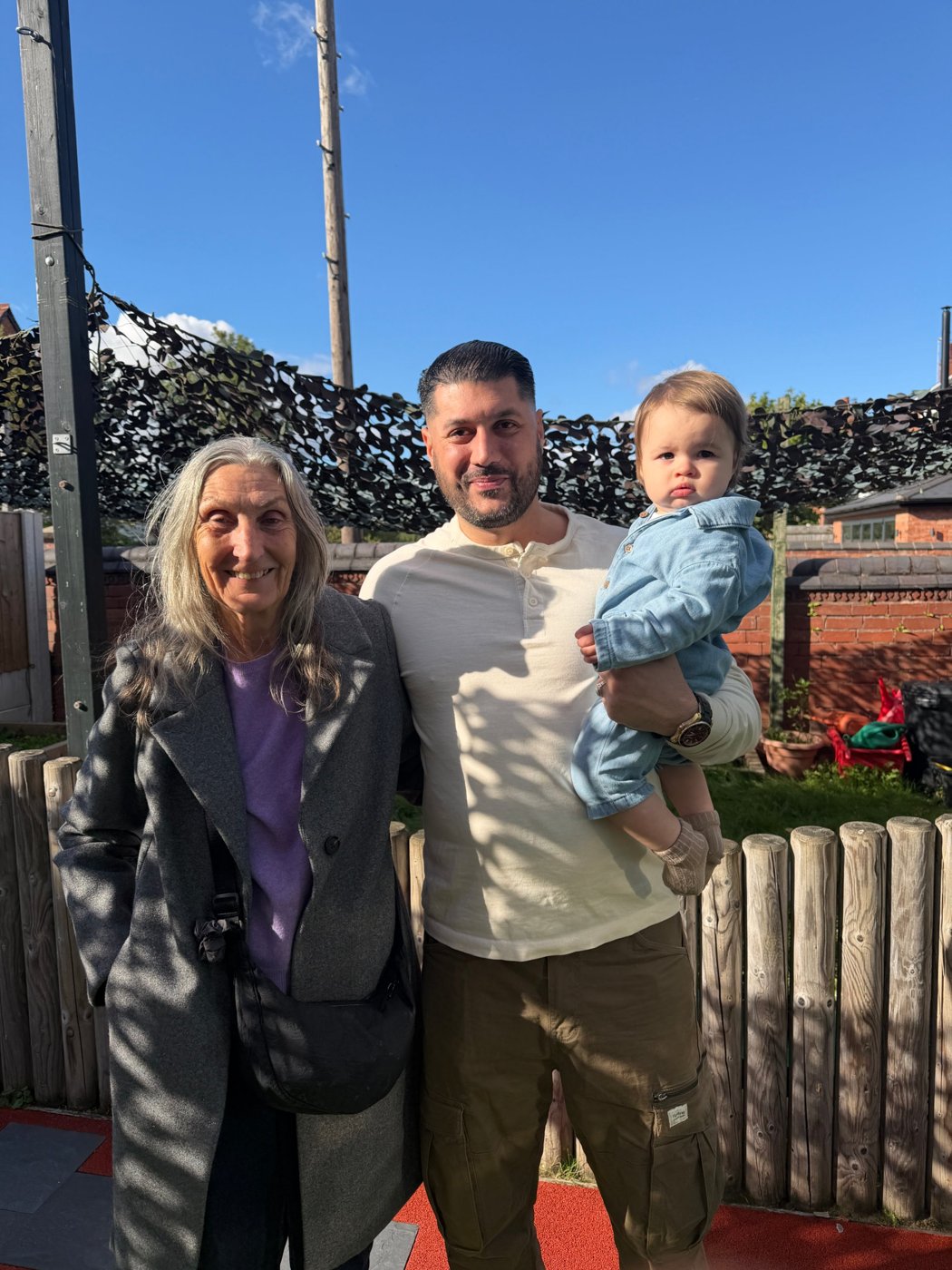 Noreen with Michael, holding Isabella, in the garden at The Cornerhouse
